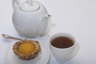 Bir fincan kahve, bir kahve ve kek masada vardır.