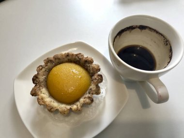 Sarhoş kahve ve kek bir fincan masada vardır.