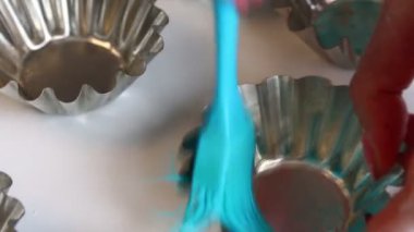 Bir kadın için kek pişirme ayçiçek yağı metal formlarla yağlar. Özel bir fırça kullanır.