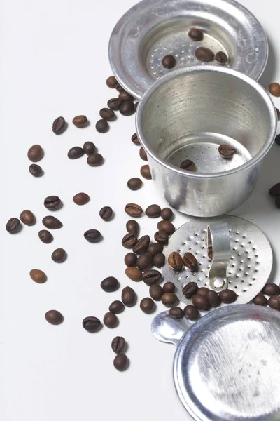 La tetera vietnamita para café en forma desmontada se encuentra en una superficie blanca. Siguiente granos de café dispersos . — Foto de Stock
