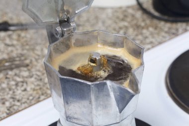 Elektrikli ocakta bir şofben kahve makinesidir. Baskı altında hazır kahve kap içinde dökülen gibi görünür.