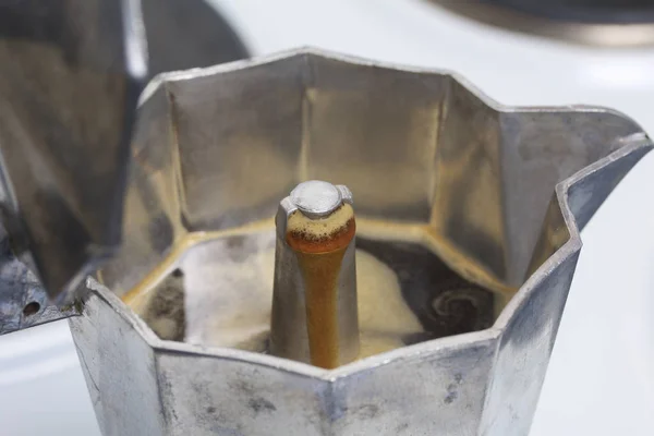 Hay una cafetera géiser en la estufa eléctrica. Es visible como el café listo bajo presión se vierte en el recipiente . — Foto de Stock