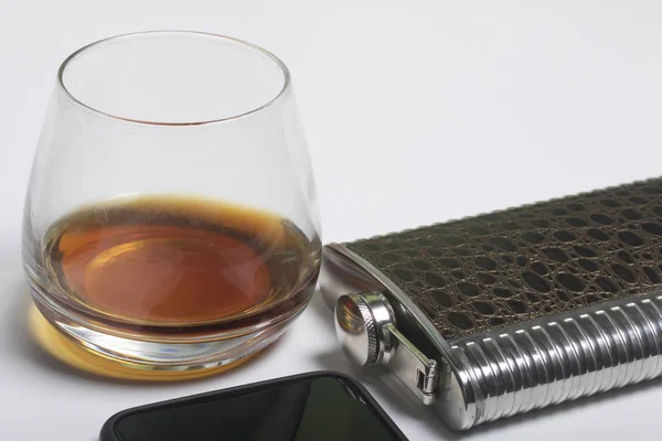 Whiskey in a glass and a flask. Next to it is a smartphone. Rest of the day off. — Stock Photo, Image