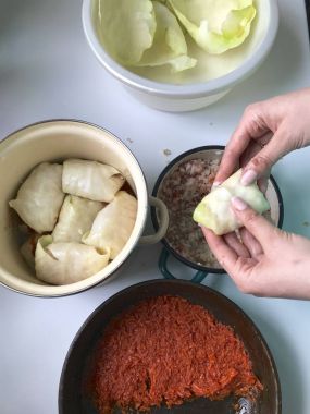Kadın doldurma Lahana yaprakları üzerinde koyar ve bu tamamladı. Hazırlanması lahana rulo. Hazırlık aşamaları. Malzemeler ve yemek hazırlanması.
