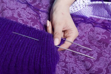 Örgü, yatakta yatan bir kadın dokuma kumaşlar. Mor dizi yapılan bir ürün.