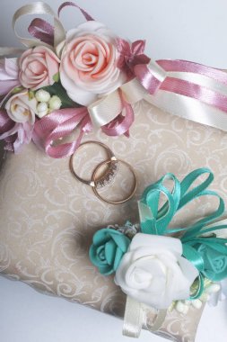 Dekor düğün. Alyans doku yüzeyinde yalan. Gelin ve damat yaka çiçeği yakınlarda bulunmaktadır.