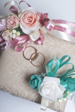 Dekor düğün. Alyans doku yüzeyinde yalan. Gelin ve damat yaka çiçeği yakınlarda bulunmaktadır.