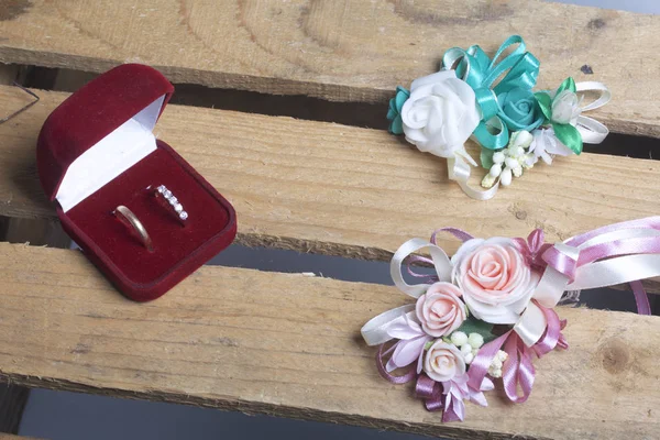 Decoração de casamento. Boutonniere noivo com a noiva, seus anéis de casamento na caixa, mentira em uma caixa de madeira . — Fotografia de Stock