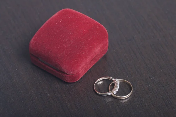 Wedding decor. Wedding rings lie on dark surface. — Stock Photo, Image