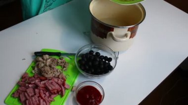 Kadın konserve dökülen içine et suyu rendelenmiş salatalık. Çorba saltwort. Yemek pişirmek için unsurlarıdır masaya