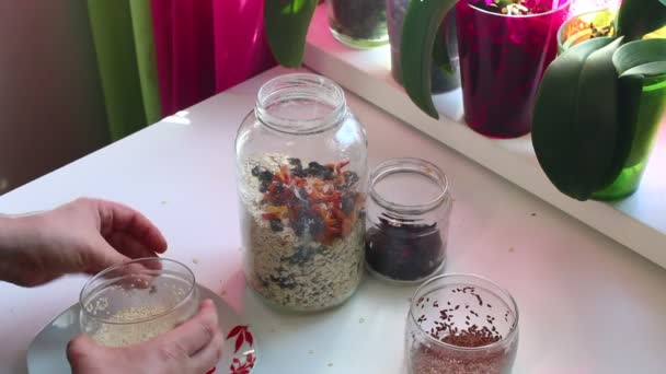 该名男子添加了亚麻和芝麻的种子 玻璃罐子得到麦片 — 图库视频影像