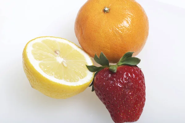 На столі лежать фруктів та ягід: суниці, лимона і Ефірна. — стокове фото