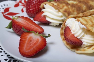 Waffle boynuzları ile krem, çilek ile dekore edilmiş.