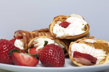 Waffle boynuzları ile krem, çilek ile dekore edilmiş.
