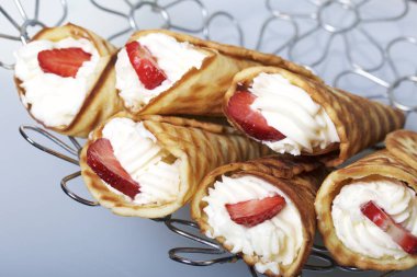 Waffle boynuzları ile krem, çilek ile dekore edilmiş.