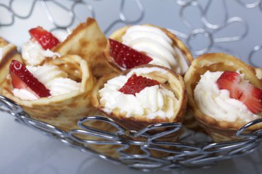 Waffle boynuzları ile krem, çilek ile dekore edilmiş.