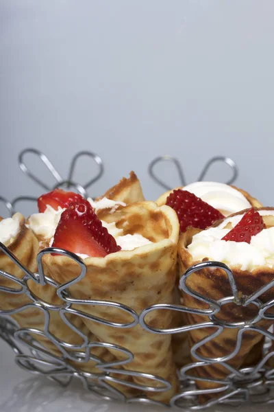 Cuernos de gofre con crema, decorados con fresas . — Foto de Stock