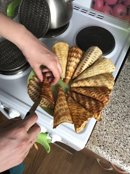 Bakken wafel hoorns voor vullen ze met crème en aardbeien. — Stockfoto