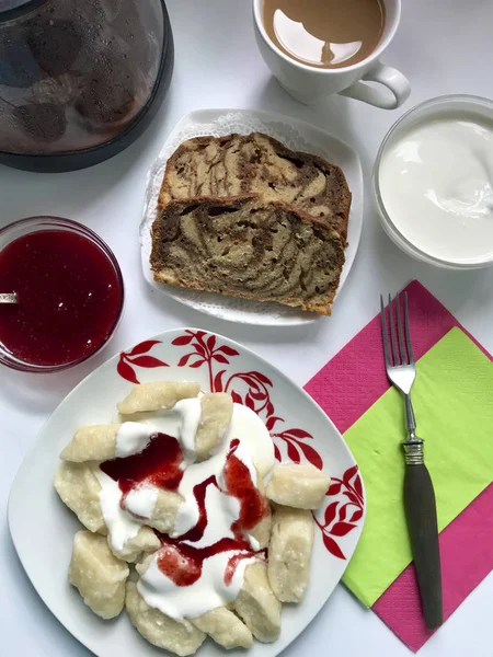 Sobre la mesa hay un plato con albóndigas perezosas, de donde sale el vapor. Añadido crema agria y mermelada . — Foto de Stock