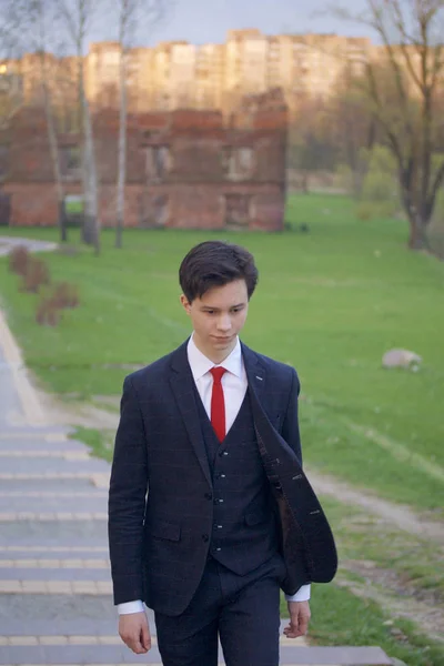 Genç bir adam, Klasik takım elbiseli bir genç. Bahar Parkı caddeleri yürüyüş. — Stok fotoğraf
