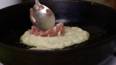 Kadın patatesli gözleme ve kıyma yapıyor. Patates püresinin üstüne kıyma yığar..