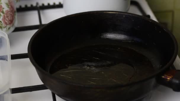 Жінка кладе гілочку розмарину на гарячу сковороду . — стокове відео