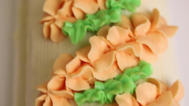 Spons cake roll bedekt met room. Versierd met een crème van verschillende kleuren. — Stockvideo