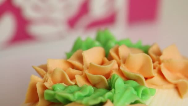 Spons cake roll bedekt met room. Versierd met een crème van verschillende kleuren. Close-up — Stockvideo