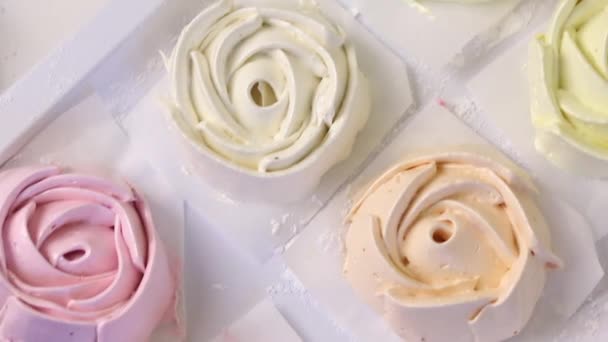 På ytan av bordet spred hemmagjorda marshmallows av olika färger och former. Benfri i pulversocker. Skjuten uppifrån närbild. — Stockvideo
