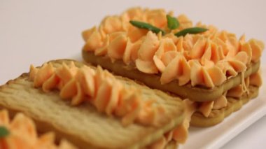 Kurabiye ve kremalı pasta. Nane yapraklarıyla süslenmiş. Yakın çekim.