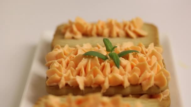 Galletas y pasteles de crema. Decorado con hojas de menta. Primer plano de disparo . — Vídeo de stock