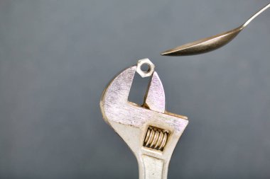 Fındık ve kaşıkla ayarlanabilir İngiliz anahtarı. Kaşıkla beslenme taklidi.