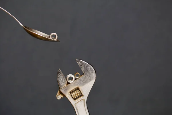 Adjustable wrench and spoon with nut. Imitation of spoon feeding. — Stock Photo, Image
