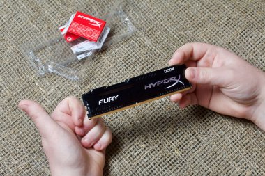 Minsk, Belarus - 25 Kasım 2019: Bir adam elinde Ram Hyperx Fury 8gb Ddr4 çubuğu tutuyor. Yakınlarda ondan gelen bir paket var. Baş parmağı gösterir.