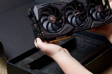 Minsk, Belarus - 25 Kasım 2019: Bir adam paketi Rog Strix Geforce Gtx 1660 Ti Advanced Edition 6gb grafik kartıyla açıyor. Cihazın soğutucularını görebilirsiniz..