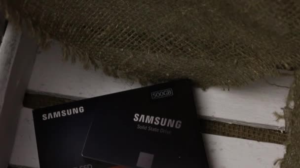 Белярус - 25 ноября 2019 года: Samsung 860 Evo 500GB SSD жесткий диск. Диск находится рядом с упаковкой в деревянной коробке — стоковое видео