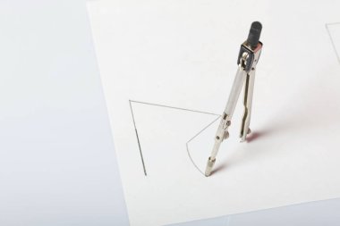 Beyaz kağıda pusula tarafından çizilmiş bir figür. Uzayda üçgen, daire ve pusula.