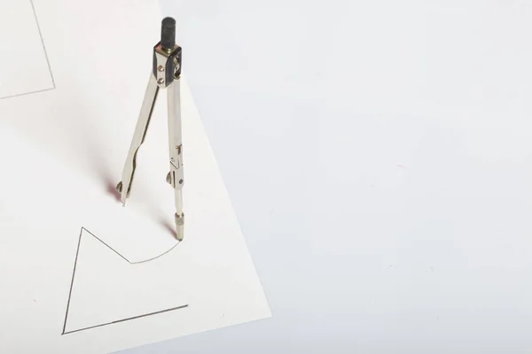 Een figuur getekend door een kompas op wit papier. Driehoek, cirkel en kompas in de ruimte. — Stockfoto