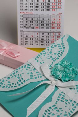 Bej renkli tebrik kartı ve bir el işi kutusunda hediye. Yakınlarda takvimin Aralık ayı ile birlikte bir parçası var..