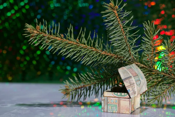 Open chest with gifts. Against the background of a fir branch and rainbow bokeh.