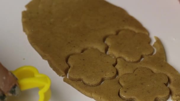 Woman is preparing gingerbread cookie. In the rolled dough, she squeezes the cookie blanks using a mold. — Stock Video