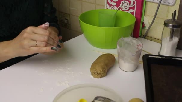 Een vrouw bereidt een deeg voor peperkoeken. Kneed het met zijn handen en rolt een deegroller op tafel. — Stockvideo