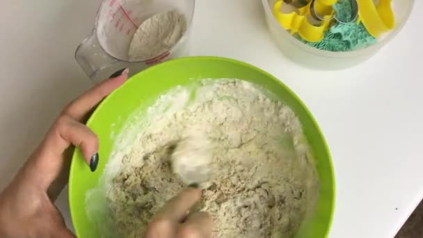 Una donna mescola gli ingredienti dei biscotti di pan di zenzero in un contenitore. Vicino agli utensili da cucina. Vista dall'alto . — Video Stock