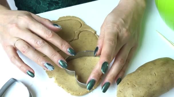 여자가진저 브레드 쿠키를 준비중이에요. 반죽을 으깬 다음틀을 사용하여 쿠키의 플럼을 짜낸다. 위에서 발사 — 비디오