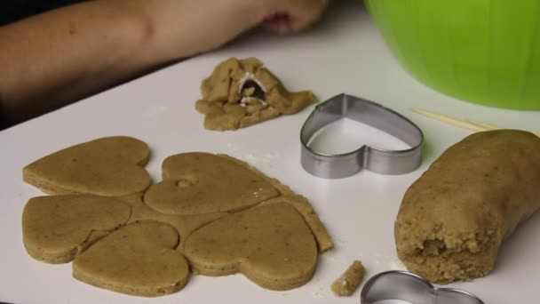 Vrouw bereidt peperkoekkoekje. Snijd een stuk deeg in de vorm van deeg op een stokje. — Stockvideo