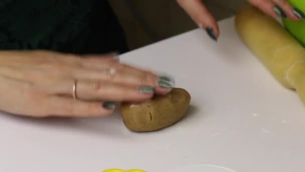 La mujer está preparando galletas de jengibre. Ella hace rodar la masa con un rodillo . — Vídeos de Stock