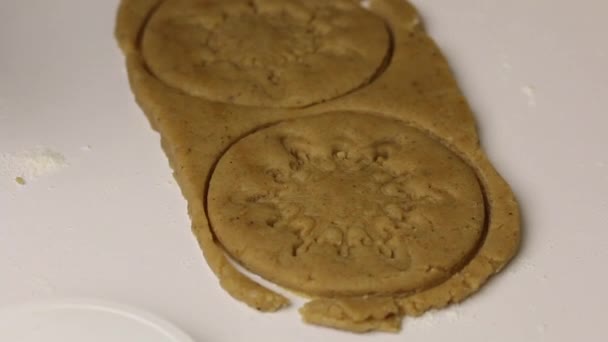 スタンプを使用して、女性はジンジャーブレッドクッキーのブランクにパターンを適用します。クローズアップショット. — ストック動画