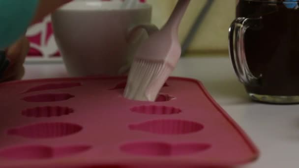 Une femme applique du chocolat liquide sous forme de silicone avec une brosse. Pour la préparation de bonbons glacés. Gros plan — Video