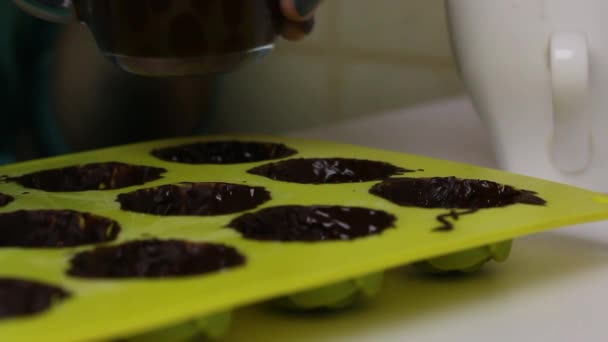 한 여자는 액체 초콜릿이 들어 있는 실리콘틀을 윤활제로 만듭니다. 유약을 탄 단 음식을 만들기 위한 것이다. 근접 촬영 — 비디오