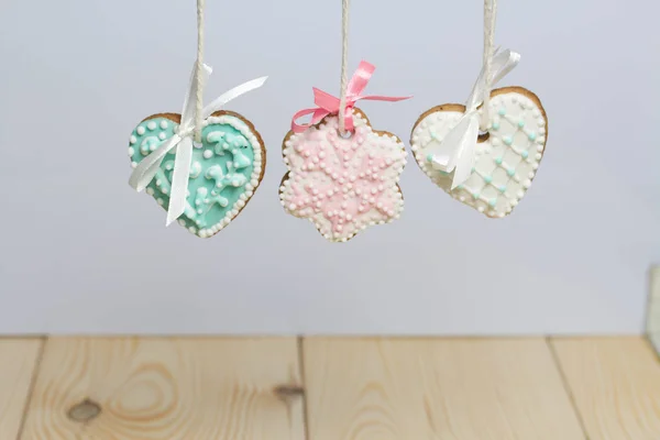 Spicy gingerbread cookie decorated with multi-colored sugar icing. Suspended on a cord. Decorated with spruce branch.